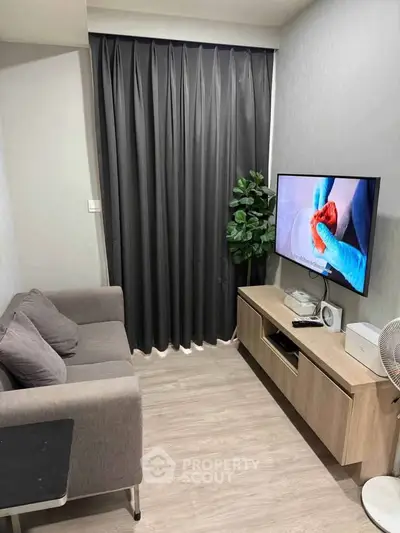 Cozy modern living room with sleek furniture and wall-mounted TV, perfect for relaxation.