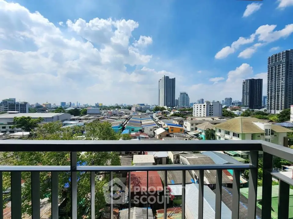 Stunning cityscape view from a high-rise balcony with clear blue skies and modern buildings.