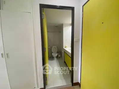 Compact bathroom with yellow accents and modern fixtures
