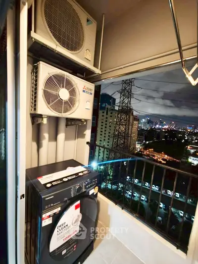 High-rise balcony with city view featuring washing machine and air conditioning units.
