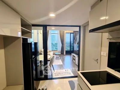 Modern apartment with open kitchen and spacious living room featuring a balcony view.