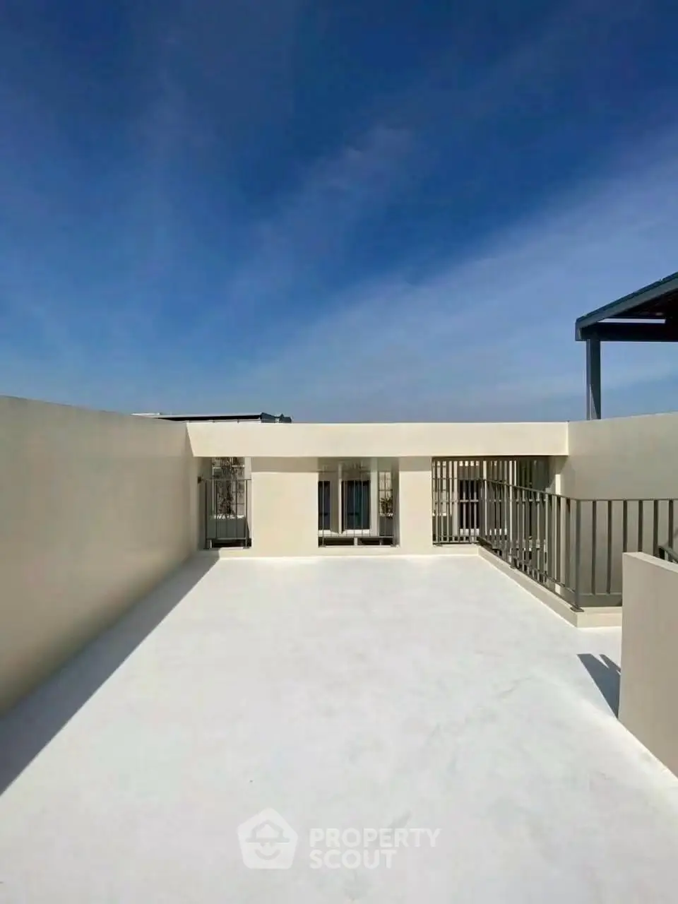 Spacious rooftop terrace with clear blue sky, perfect for outdoor relaxation and entertainment.