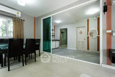 Spacious dining area with glass table and sliding doors in modern apartment
