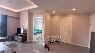 Modern living room with sleek design and bedroom view, featuring glossy tiled floors and ambient lighting.