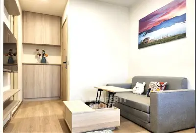 Cozy living room with modern decor and wooden flooring, featuring a comfortable sofa and stylish wall art.