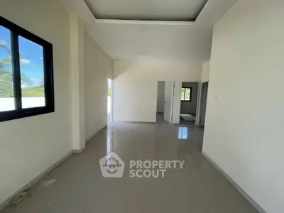 Spacious empty room with large window and glossy floor, ideal for customization.