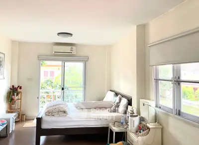 Bright and airy bedroom with large windows and cozy decor
