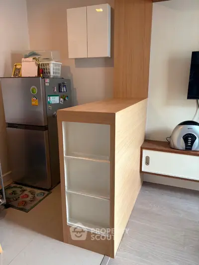 Modern kitchen with sleek wooden cabinetry and stainless steel fridge