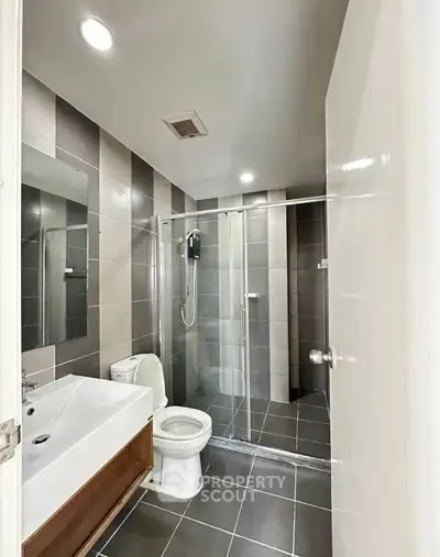 Modern bathroom with sleek design and glass shower enclosure.