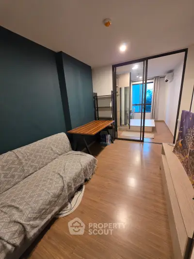 Modern living room with stylish decor and sliding glass doors leading to a bright bedroom.