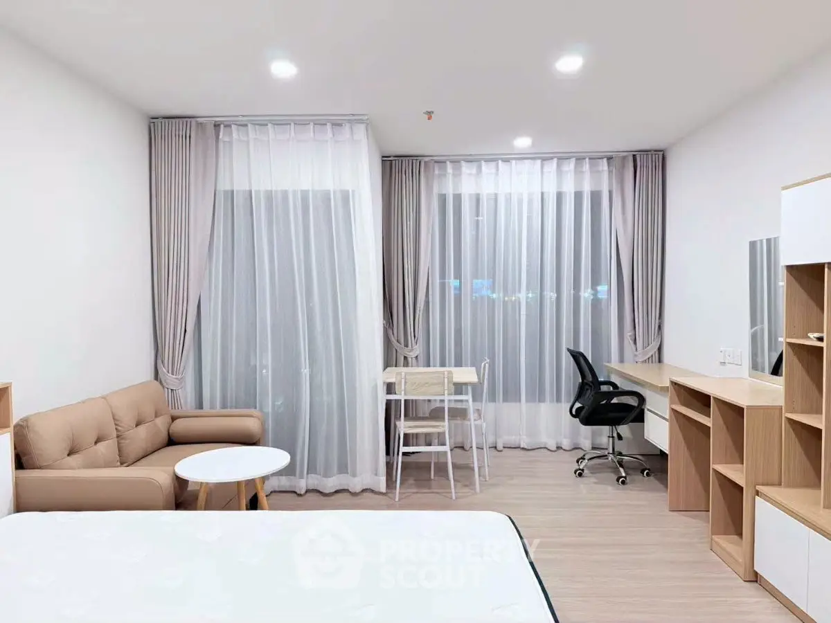 Modern studio apartment with cozy living area and workspace