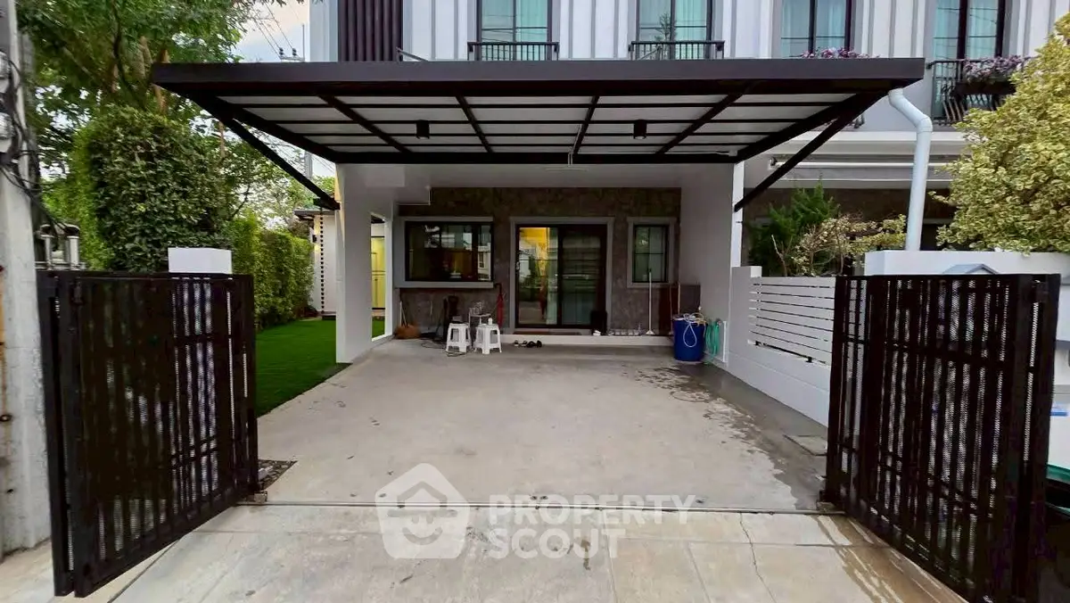 Modern house exterior with covered carport and gated entrance, perfect for family living.