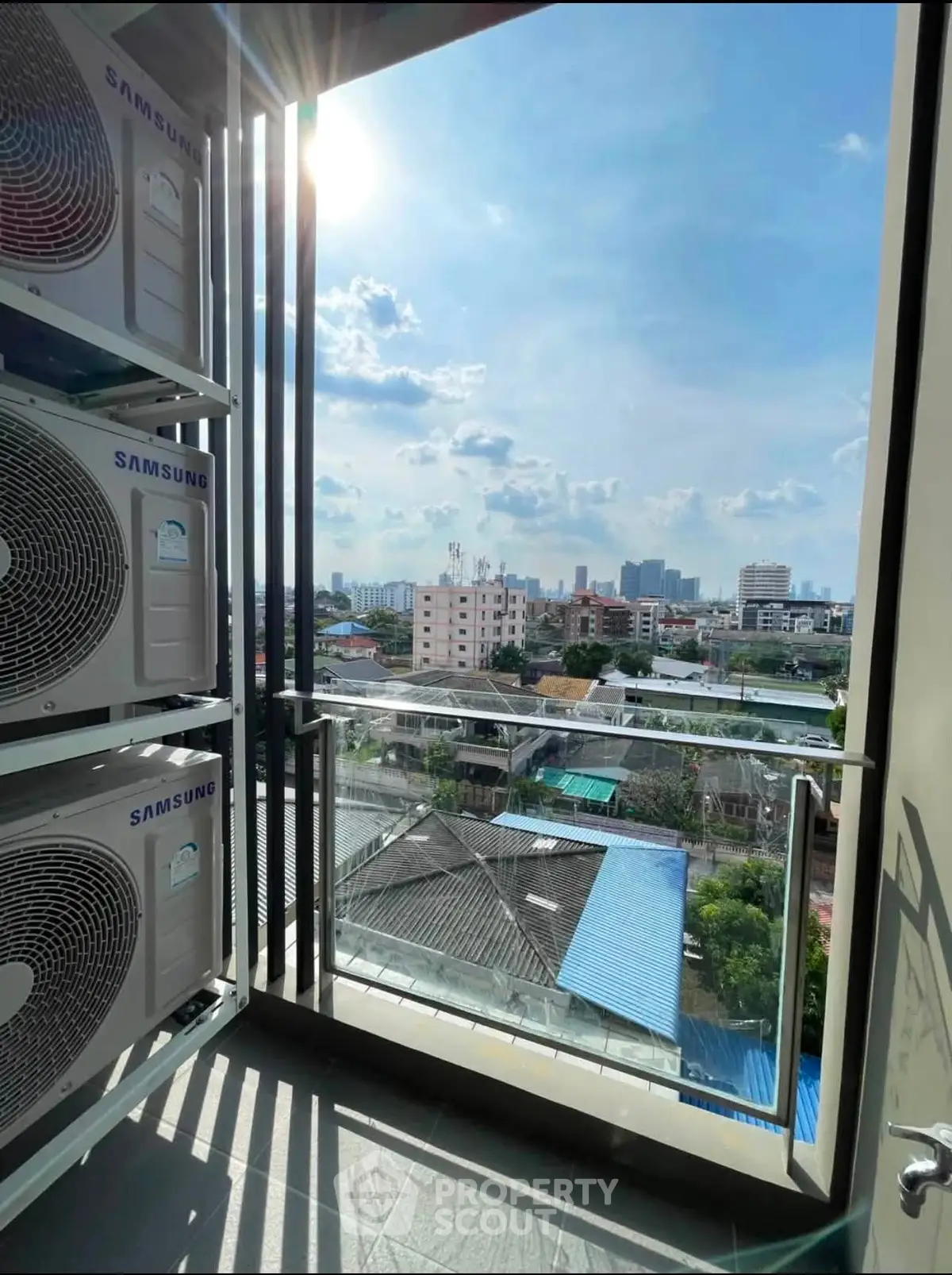 Stunning cityscape view from a modern balcony with air conditioning units, perfect for urban living.