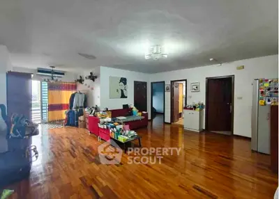 Spacious living room with wooden flooring and modern decor in a stylish apartment.