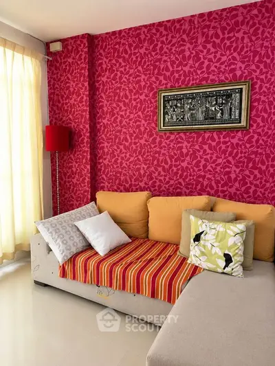 Vibrant living room with bold red wallpaper and cozy sectional sofa
