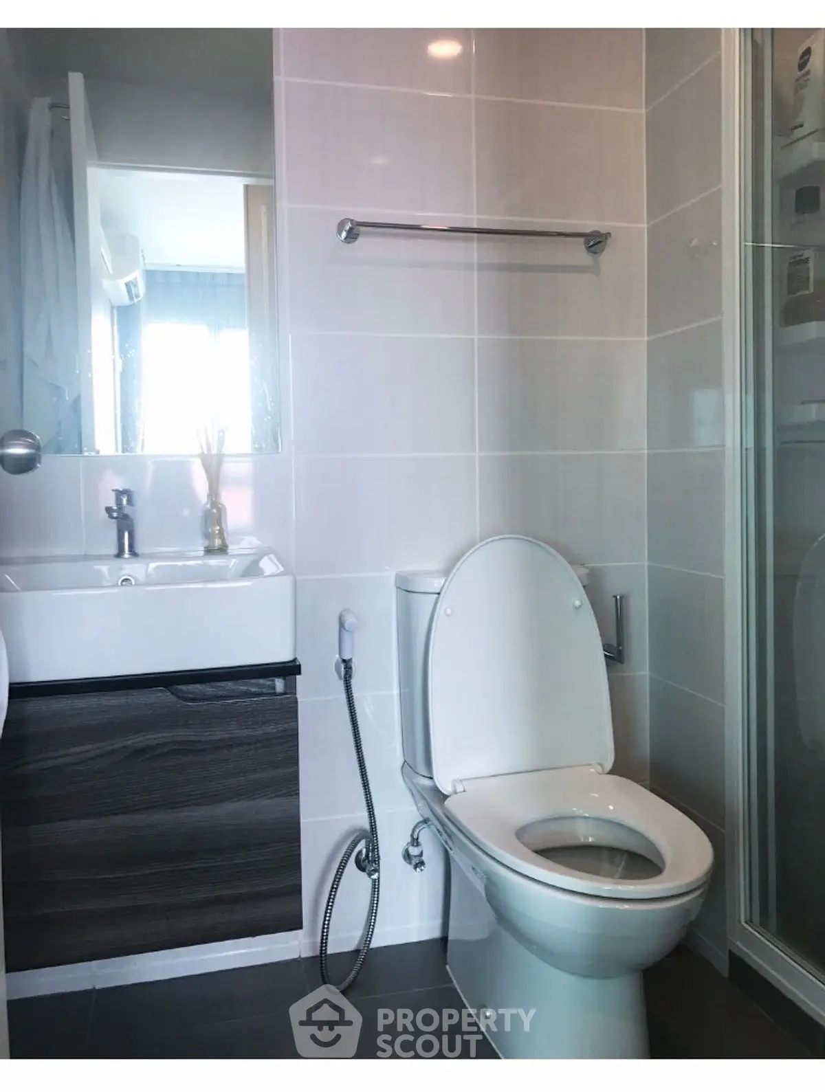 Modern bathroom with sleek fixtures and glass shower enclosure.