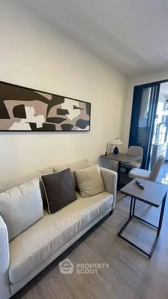 Modern living room with stylish decor and balcony access, featuring a cozy sofa and sleek furniture.