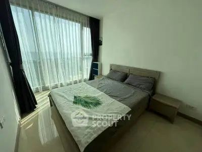 Spacious bedroom with large window offering stunning natural light and serene views.