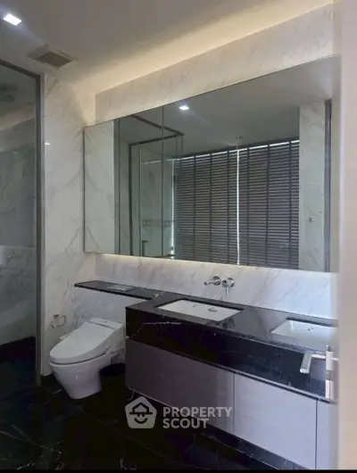 Luxurious modern bathroom with marble walls and sleek fixtures in a high-end property.