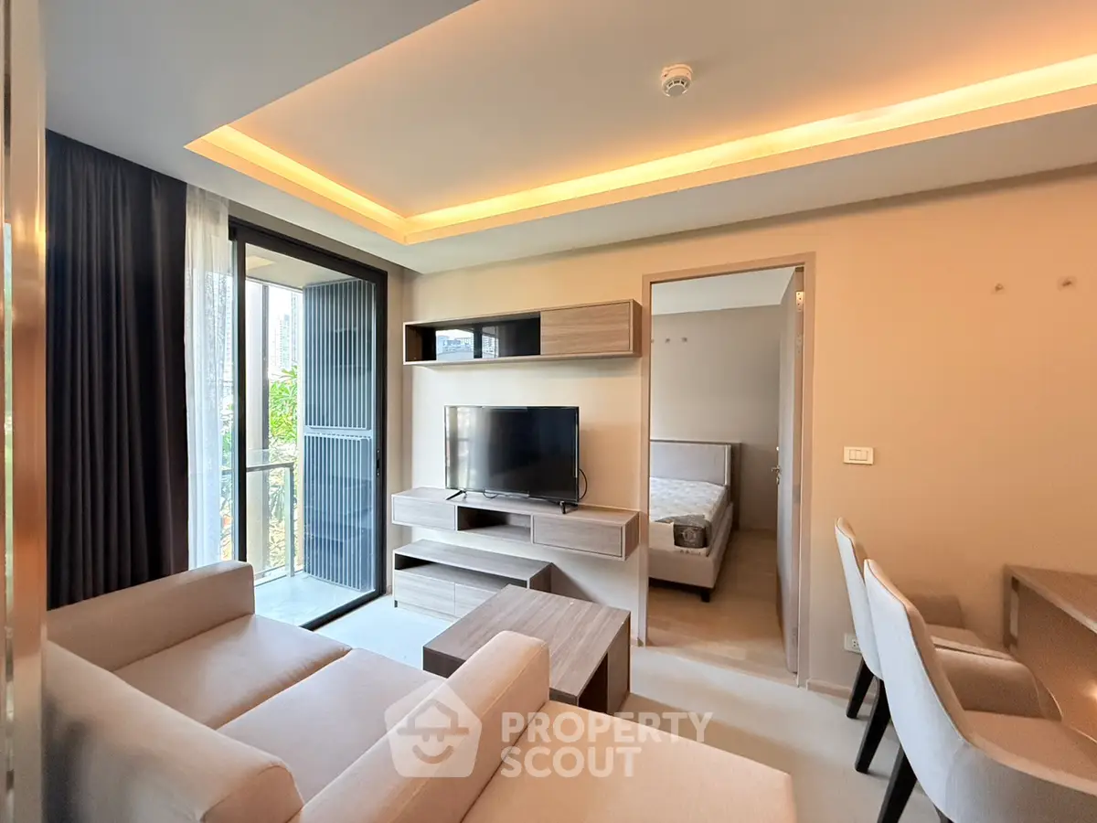 Modern living room with cozy sofa, TV, and access to a balcony in a stylish apartment.
