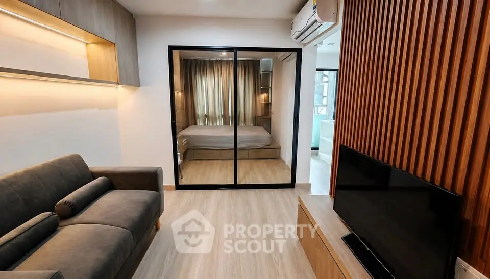 Modern living room with sleek design and mirrored wardrobe in a stylish apartment.