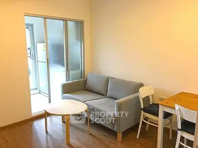Cozy living room with modern furniture and sliding glass doors leading to a bright balcony.