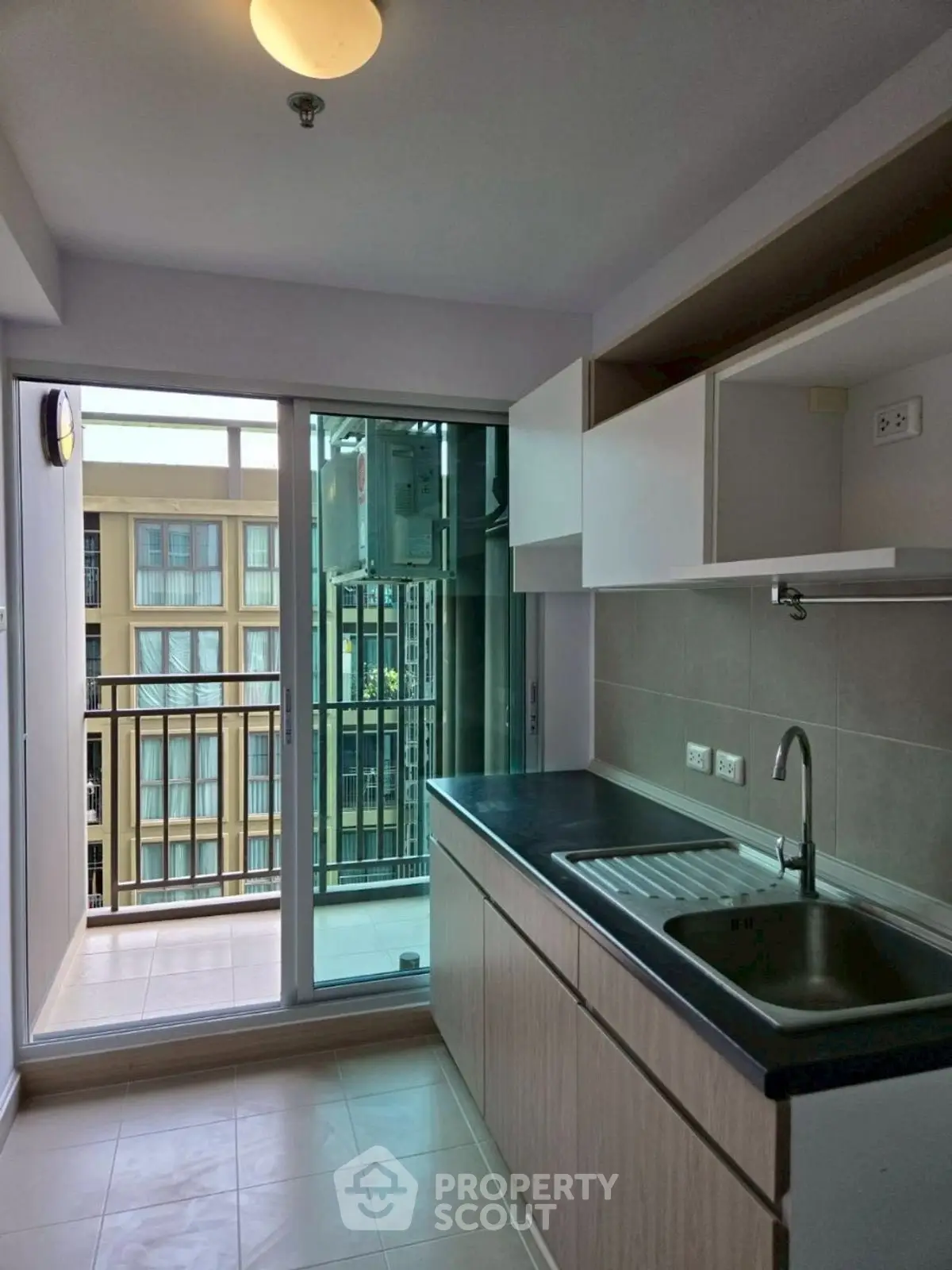 Modern kitchen with sleek cabinetry and balcony access in a stylish apartment.