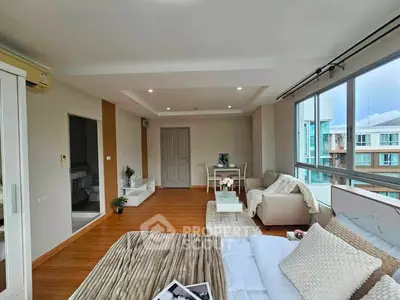 Spacious modern bedroom with large windows and cozy seating area, offering a bright and inviting atmosphere.