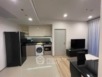 Modern open-layout kitchen and living room with sleek appliances and stylish decor.