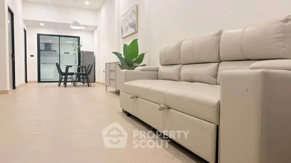 Modern living room with sleek beige sofa and dining area in open layout