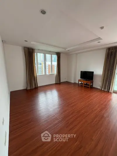 Spacious living room with wooden flooring and natural light