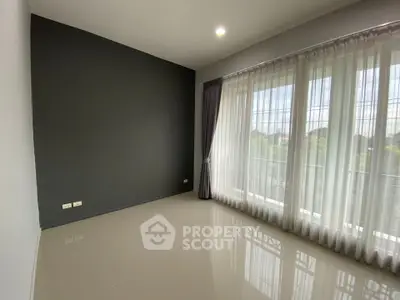 Spacious empty room with large windows and modern design, perfect for customization.