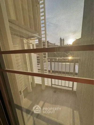 Charming balcony view with sunset over cityscape, perfect for relaxation.