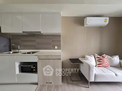 Modern compact kitchen and cozy living area with air conditioning.