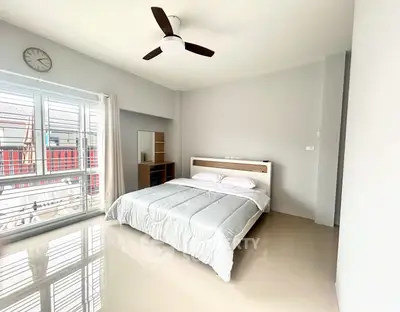Spacious bedroom with modern design and large window offering natural light.