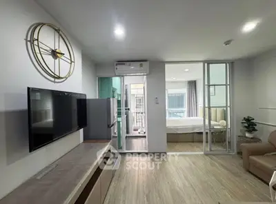 Modern open-plan living room with stylish decor and adjacent bedroom view.