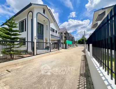 Modern two-story house with sleek design and spacious driveway in a serene neighborhood.