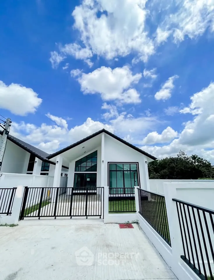 Modern single-story house with sleek design and spacious front yard under a bright blue sky.