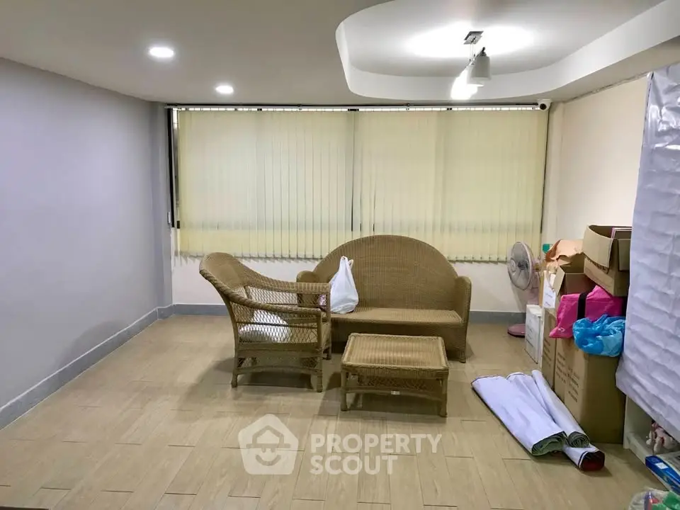 Cozy living room with wicker furniture and modern ceiling design, perfect for relaxation.