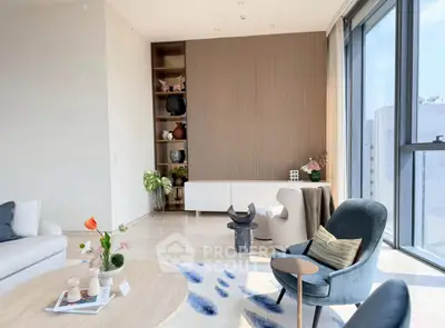 Elegant modern living room with stylish furniture and large windows offering natural light and city views.