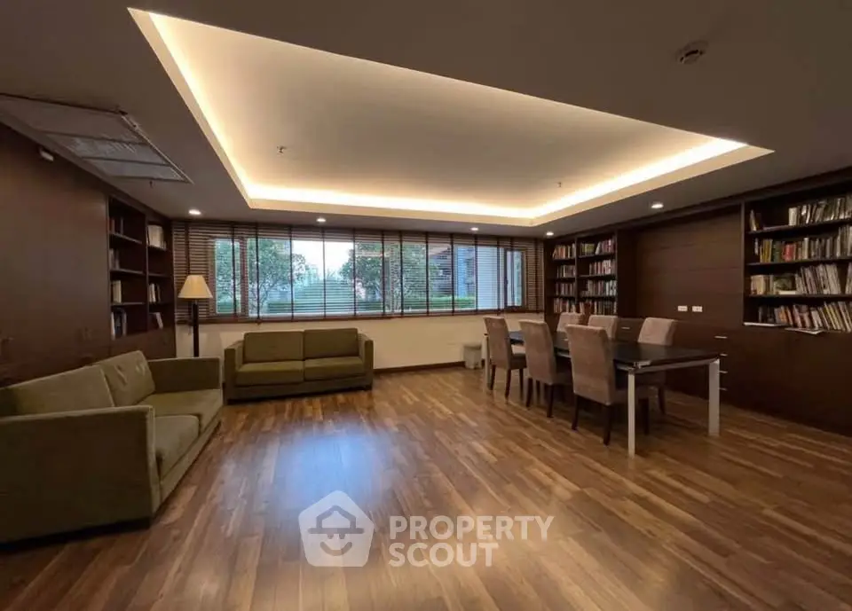 Spacious library with modern seating and large windows offering garden views