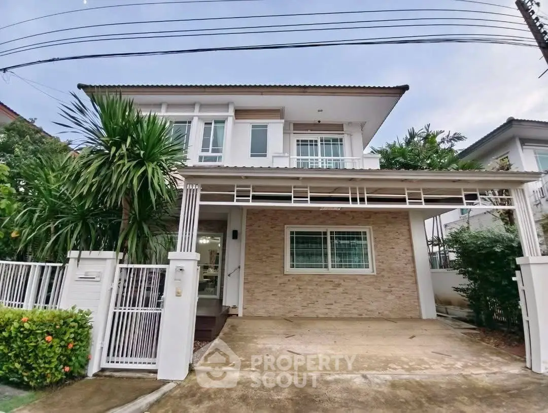 Modern two-story house with driveway and lush greenery in suburban neighborhood.