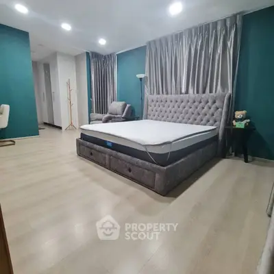 Spacious bedroom with elegant decor and modern furnishings, featuring a plush bed and stylish lighting.