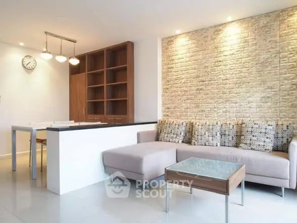 Modern living room with stylish furniture and brick accent wall