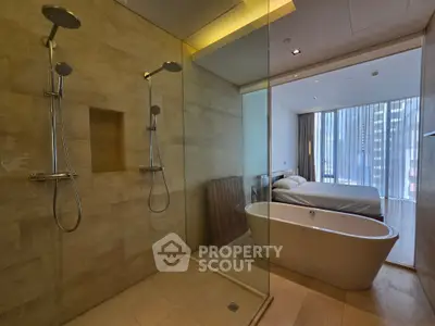 Luxurious modern bathroom with dual showers and freestanding bathtub adjacent to a stylish bedroom.