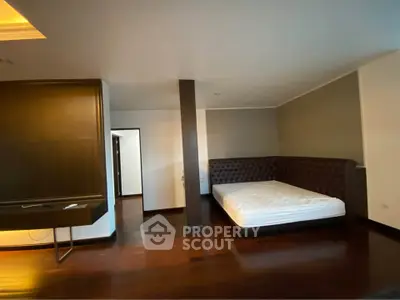 Spacious bedroom with elegant dark wood flooring and modern design