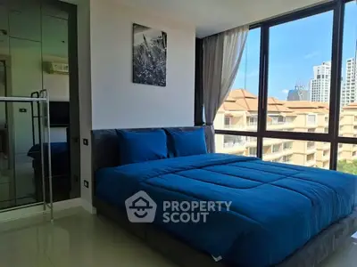 Spacious bedroom with large windows offering a stunning city view, featuring a modern bed and mirrored wardrobe.