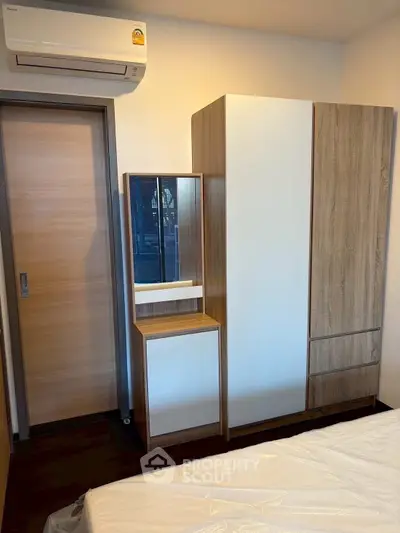 Modern bedroom with sleek wardrobe and air conditioning unit