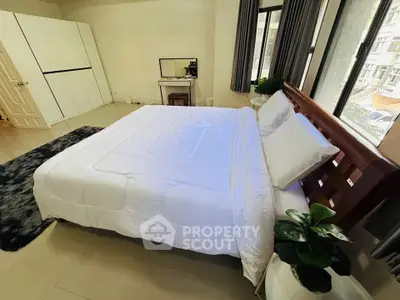 Spacious bedroom with large windows and modern decor, perfect for relaxation.