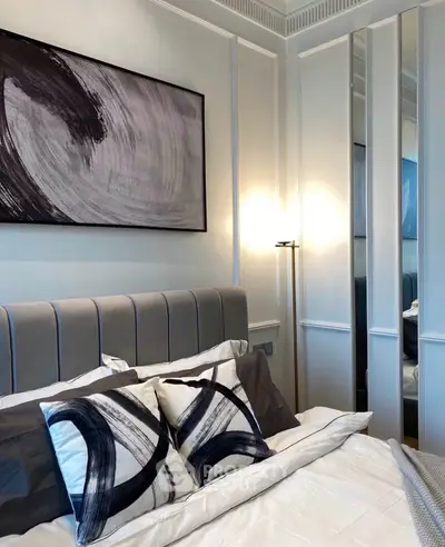 Modern bedroom with stylish decor and abstract art on the wall.